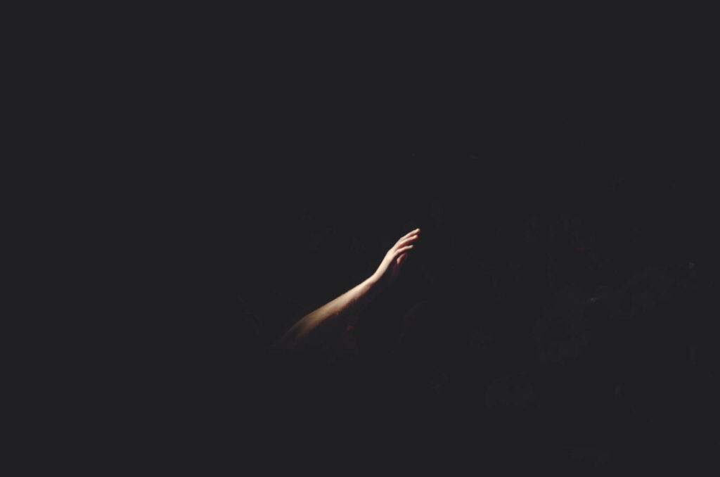 Minimalist Wallpaper: Striking Arm Emerges from Dark Background