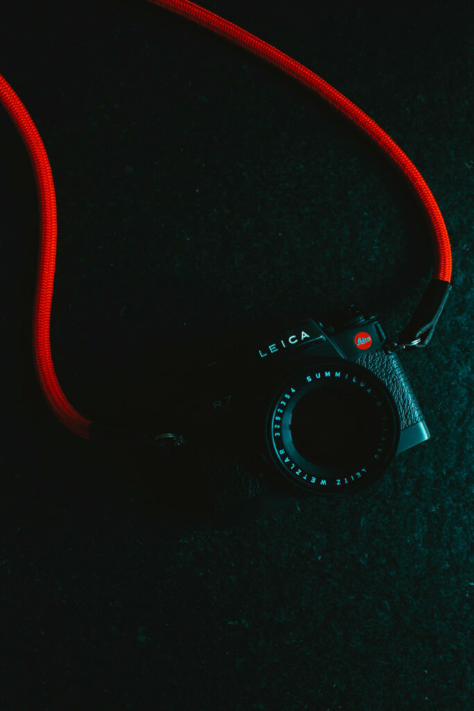 Minimalist Leica R7 Wallpaper: Dark Background & Red Strap Design