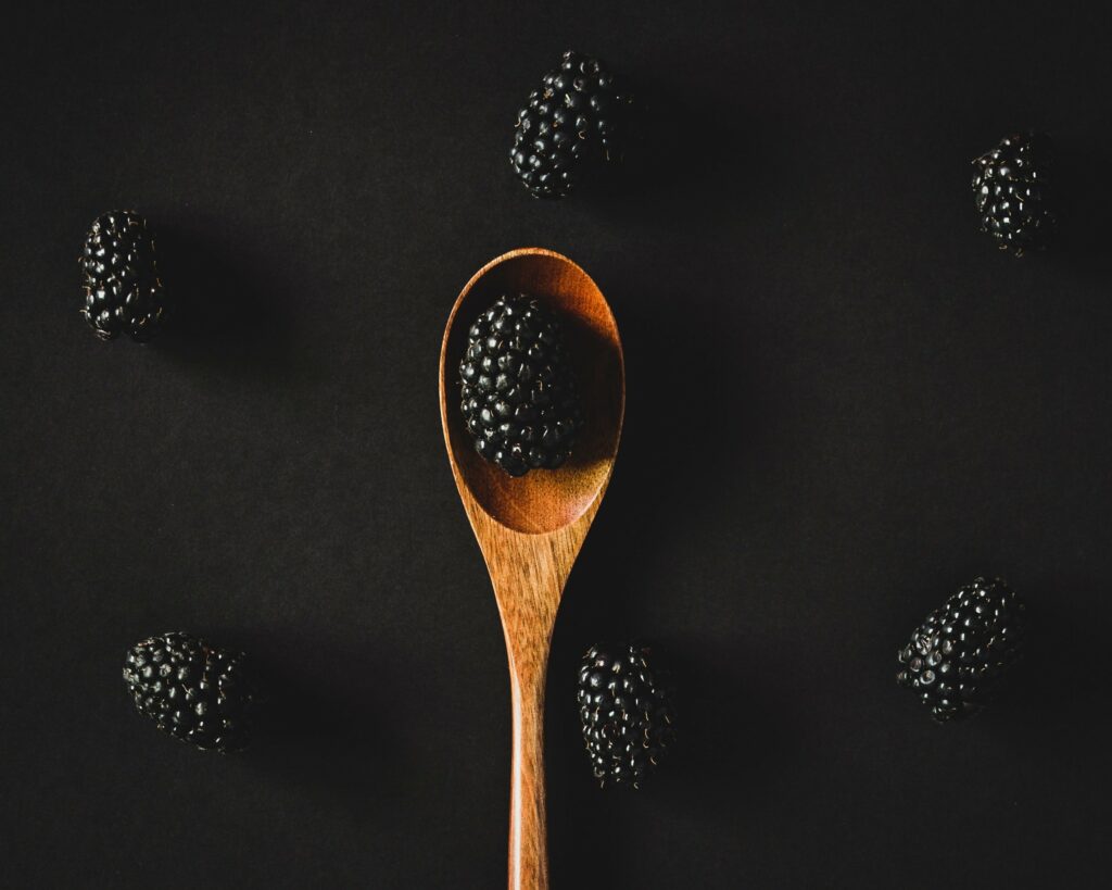 Minimalist Blackberry Wallpaper on Black Background with Wooden Spoon