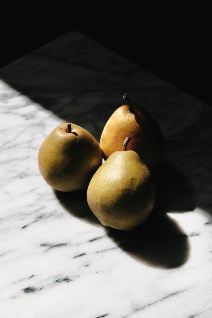 Minimalist Pear Wallpaper: Ripe Pears on Marble with Soft Shadows