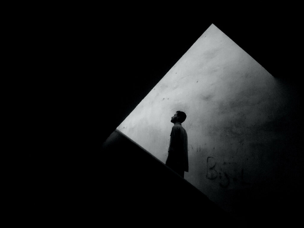 Silhouetted Figure in Minimalist Space: Contrasting Shadows & Solitude Wallpaper