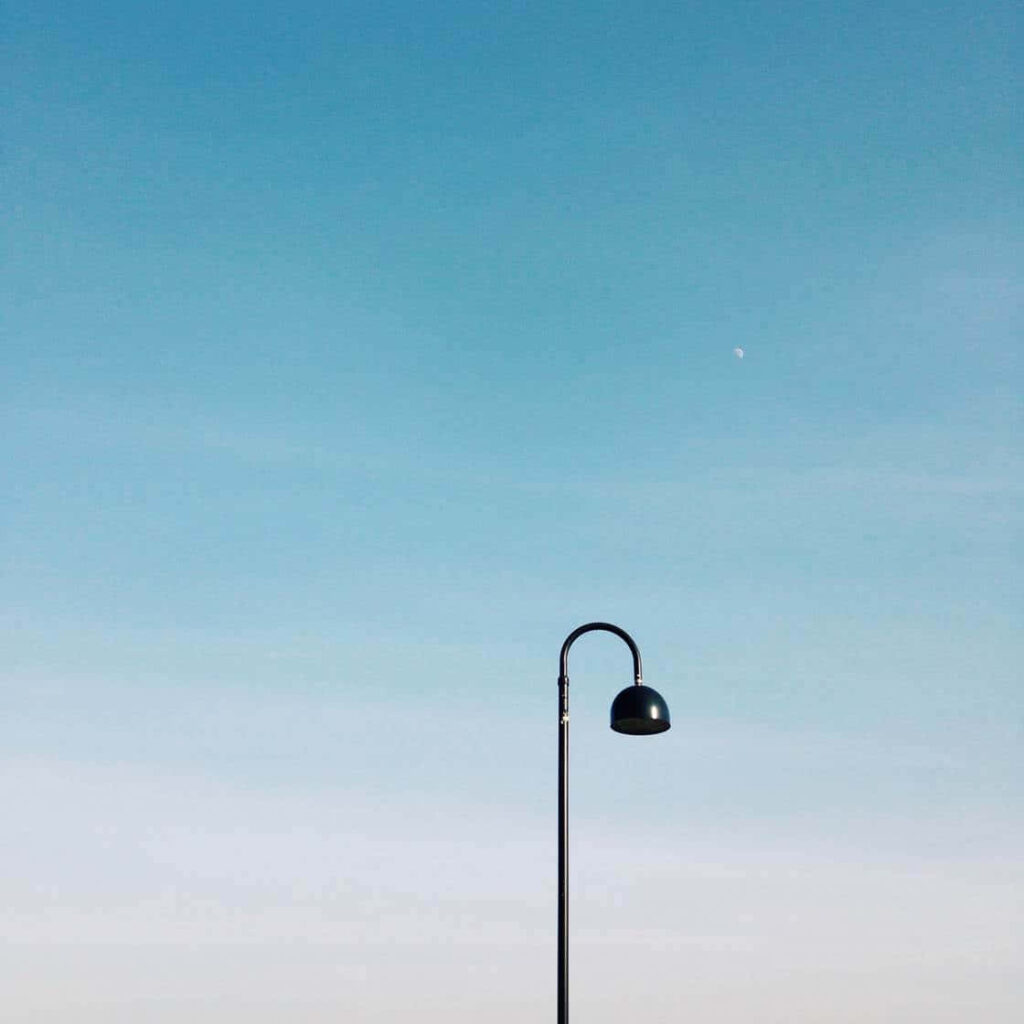 Minimalist Wallpaper: Solitary Streetlight Against Clear Blue Sky
