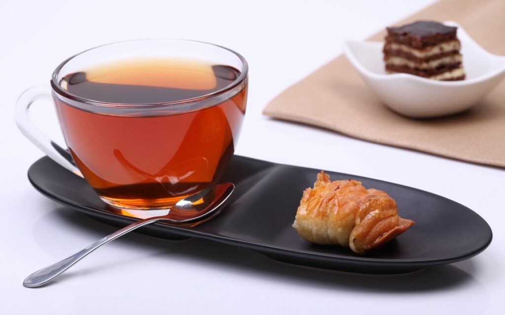 Minimalist Wallpaper: Tea & Snack on Sleek Black Plate Design