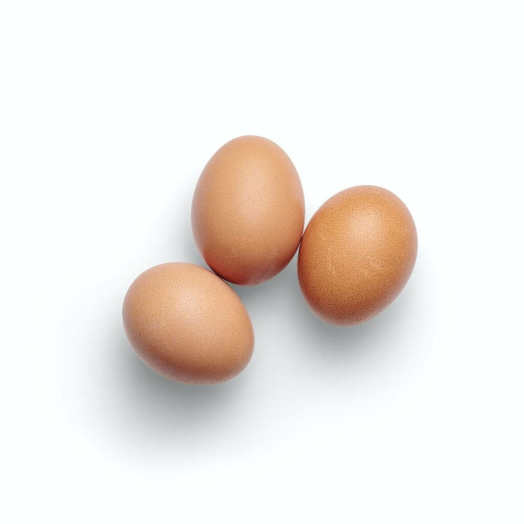 Minimalist Wallpaper: Fresh Brown Free-Range Eggs on Light Background