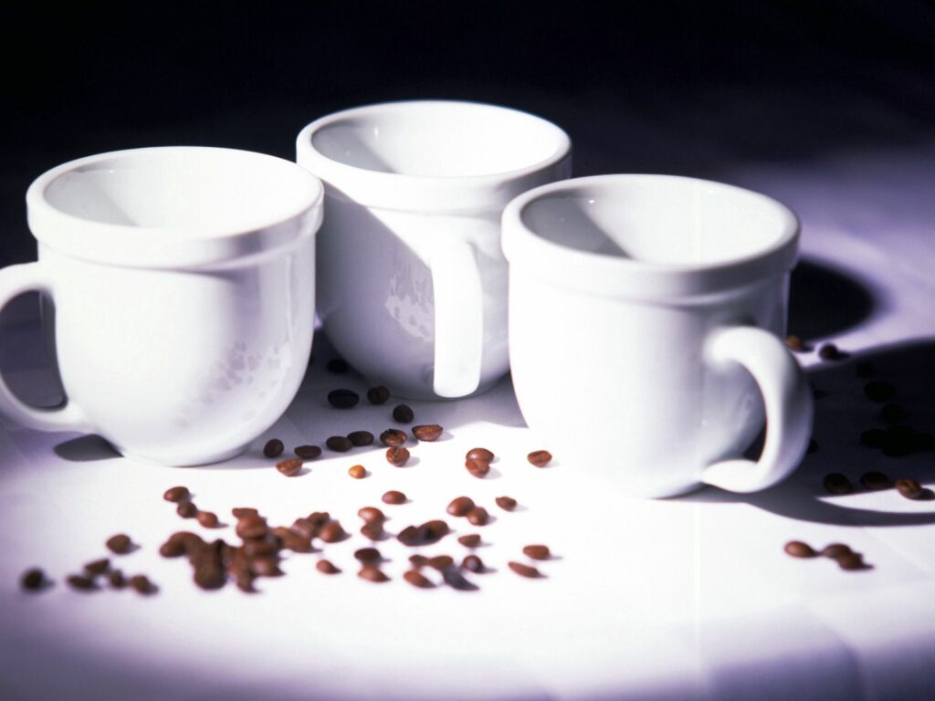 Minimalist Wallpaper: White Coffee Cups & Beans on Light Surface