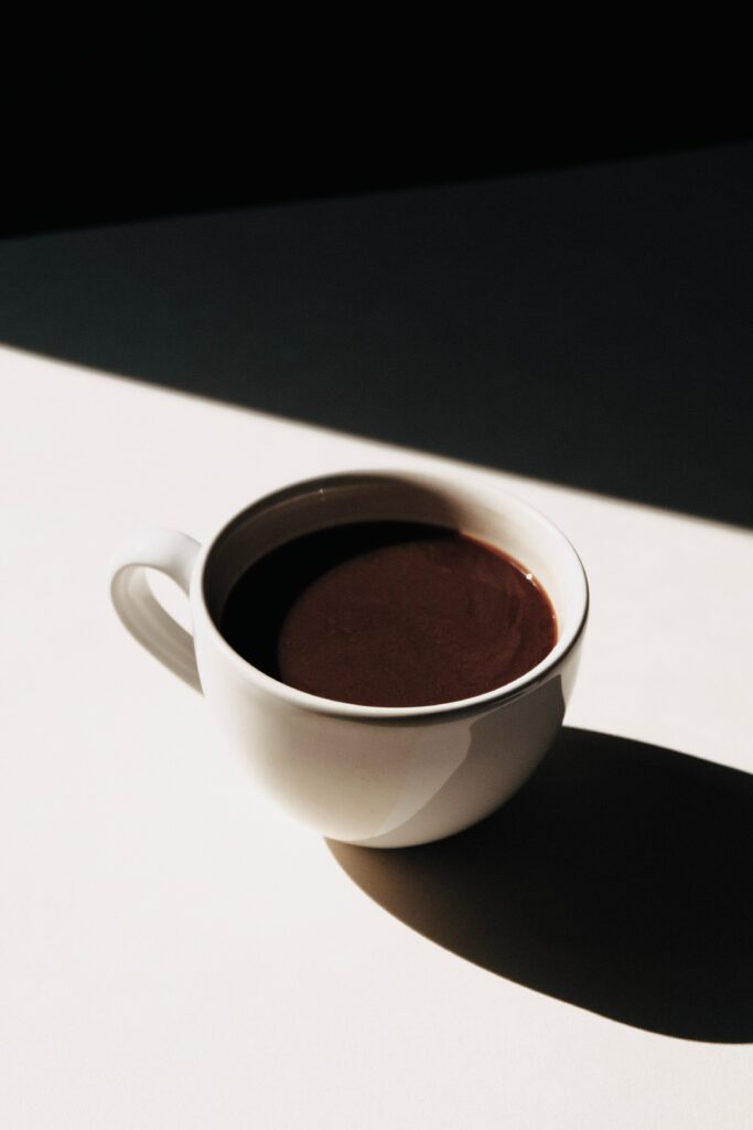 Minimalist Coffee Cup Wallpaper: Bright Shadow on Plain Surface