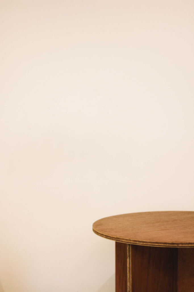 Minimalist Wallpaper with Rustic Round Table Against Plain Wall