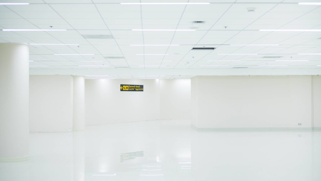 Minimalist bright white airport interior with polished floors and yellow arrivals baggage claim sign Wallpaper