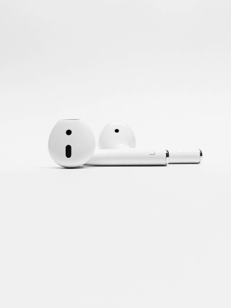 Minimalist wallpaper of sleek white Apple AirPods on a bright clean background for tech fans