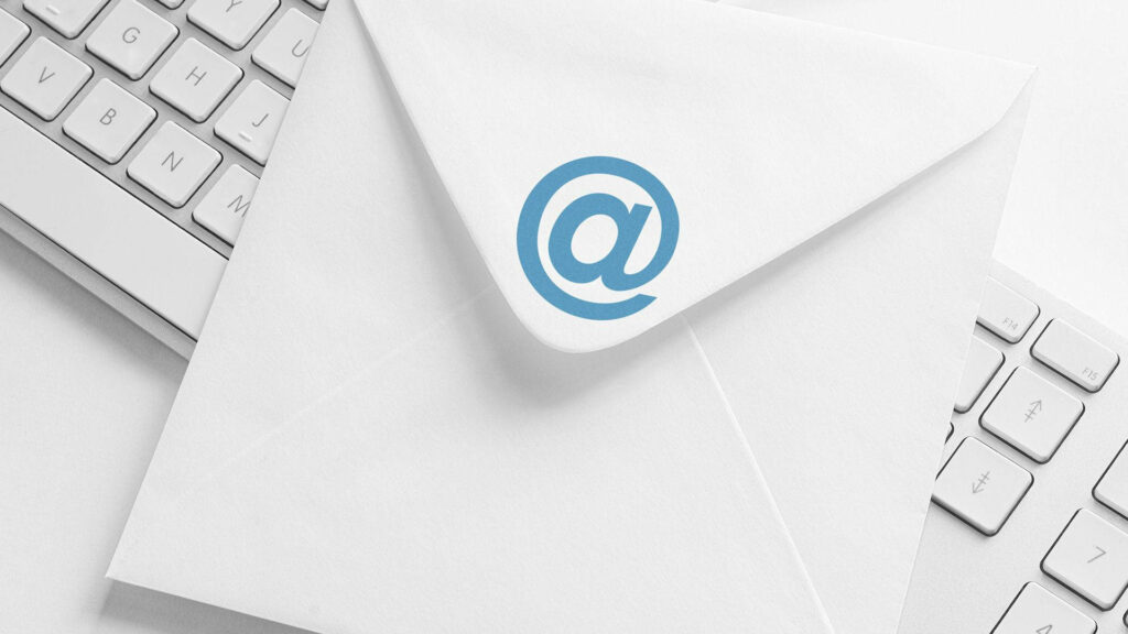 White envelope with blue email icon on white keyboard symbolizing modern digital communication Wallpaper