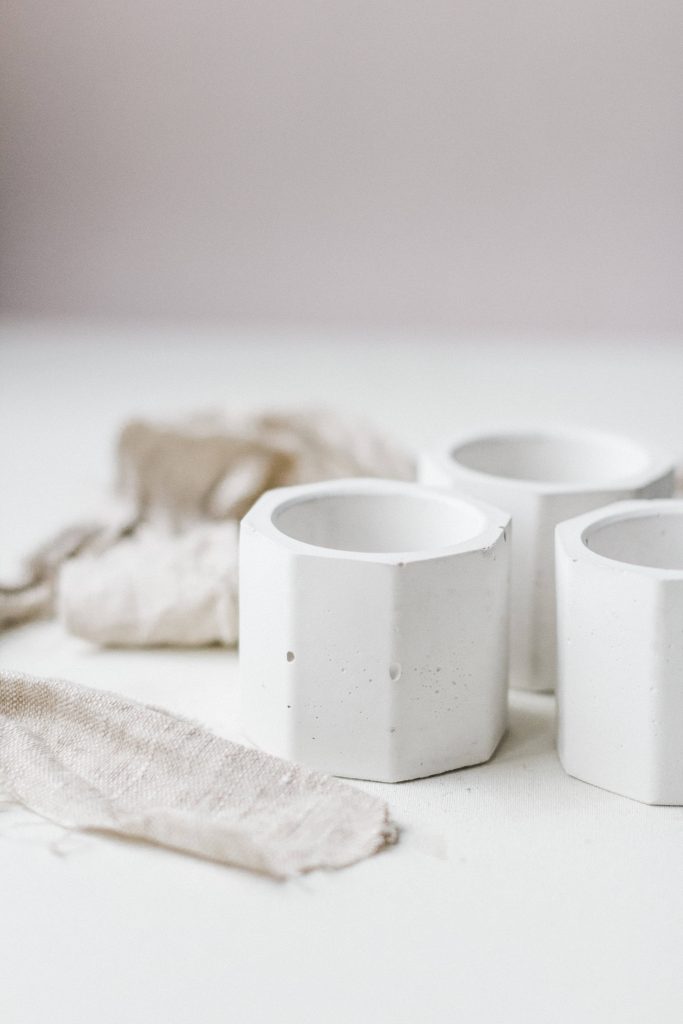 Minimalist wallpaper with three elegant hexagonal vessels in soft natural light on white backdrop