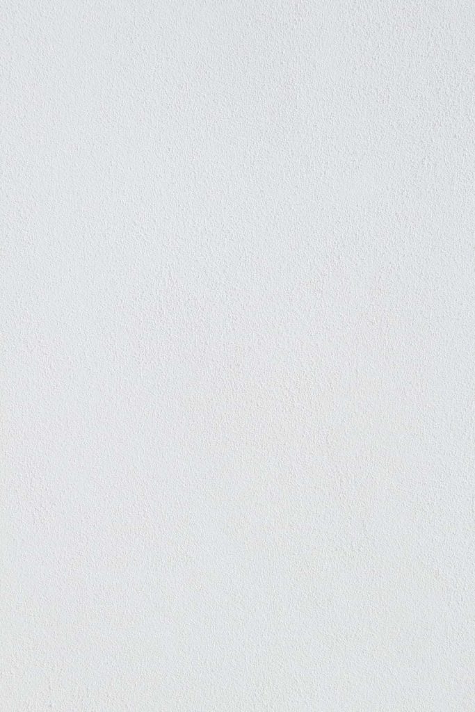 Minimalist white wall with fine matte texture perfect for clean calm desktop wallpaper background