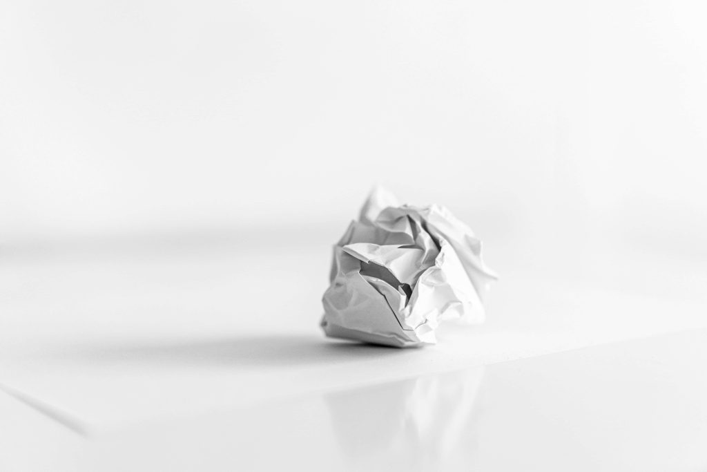Minimalist white crumpled paper ball on bright background soft high key lighting abstract wallpaper