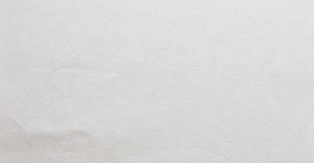 Minimalist white paper wallpaper with subtle texture and soft lighting for clean workspace