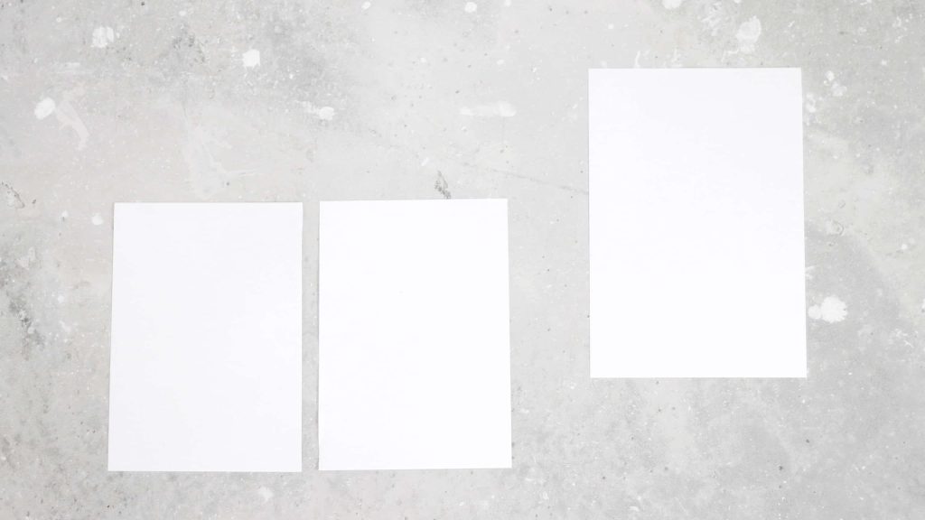 Minimalist wallpaper with three white rectangles on speckled light gray concrete background