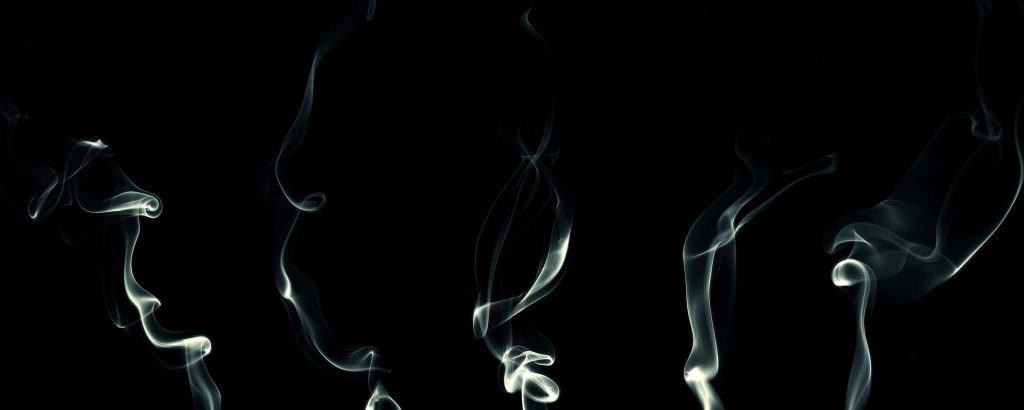 Minimalist smoke wallpaper with delicate white wisps swirling on a black background for desktop