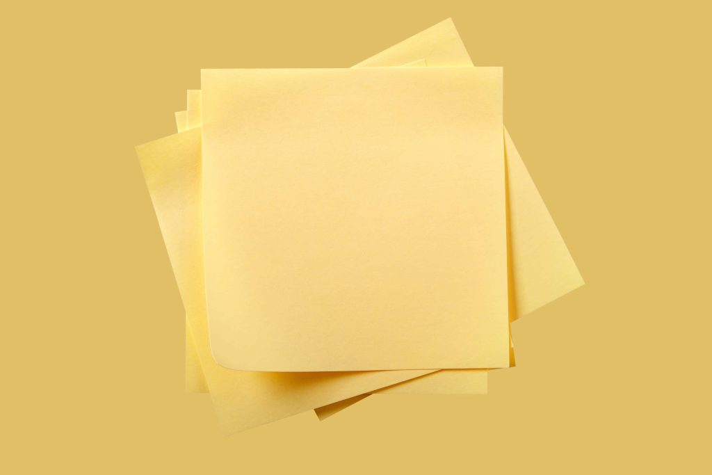Stack of blank yellow sticky notes on matching yellow background minimal desktop workspace Wallpaper