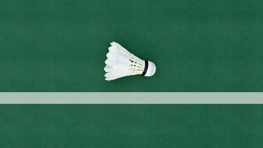 Minimalistic 720p Badminton Wallpaper: Shuttlecock on Green Court