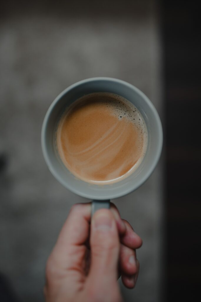 Minimalistic Wallpaper: Close-Up of Hand with Coffee Cup