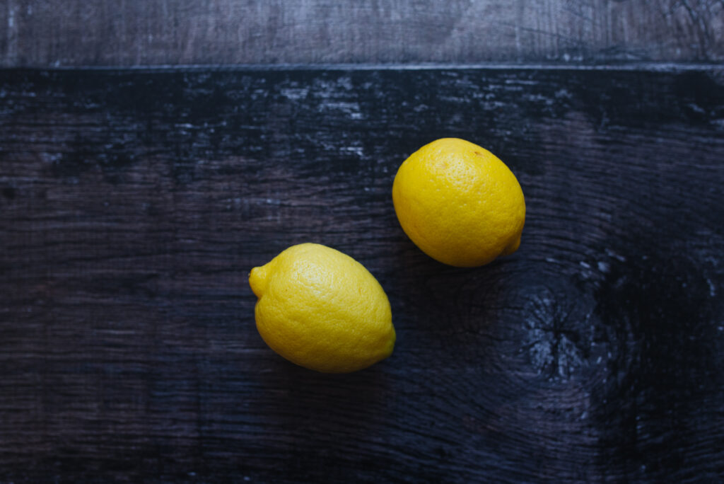 Vibrant Yellow Lemons on Dark Wood - Minimalistic Wallpaper Background