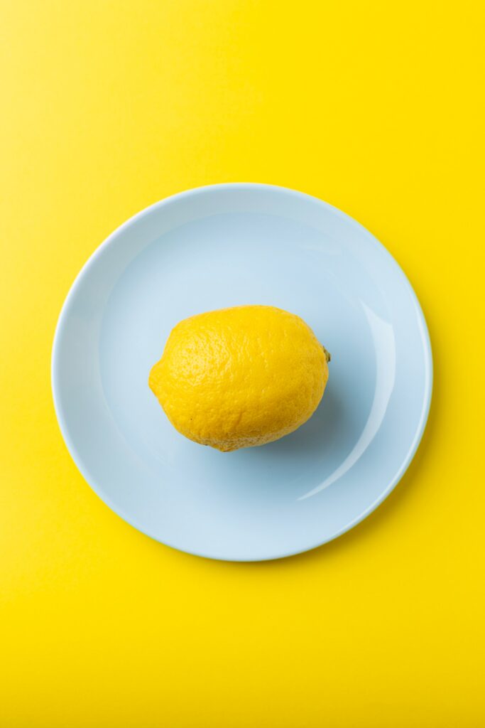 Fresh Lemon on Blue Plate: Minimalist Wallpaper Background Design