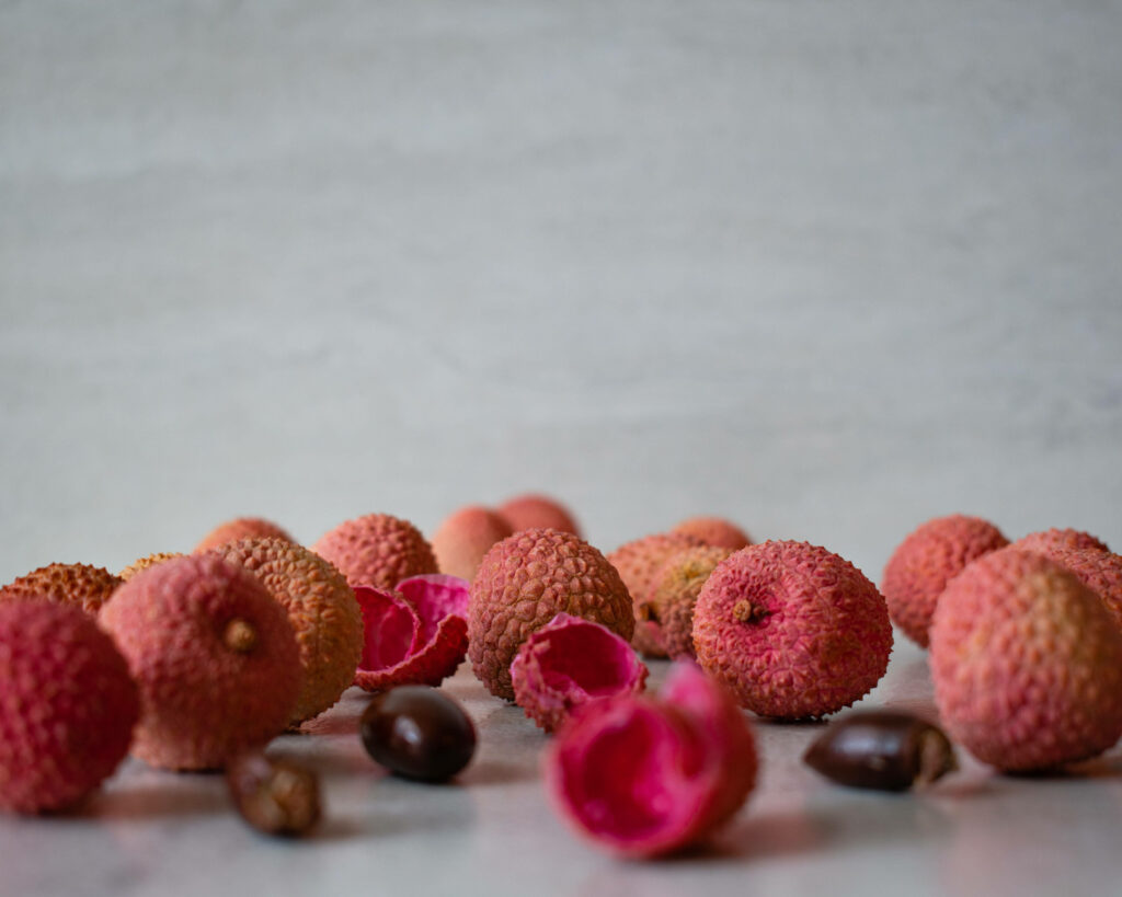 Minimalistic Pink Lychee Wallpaper with Textured Peels & Seeds