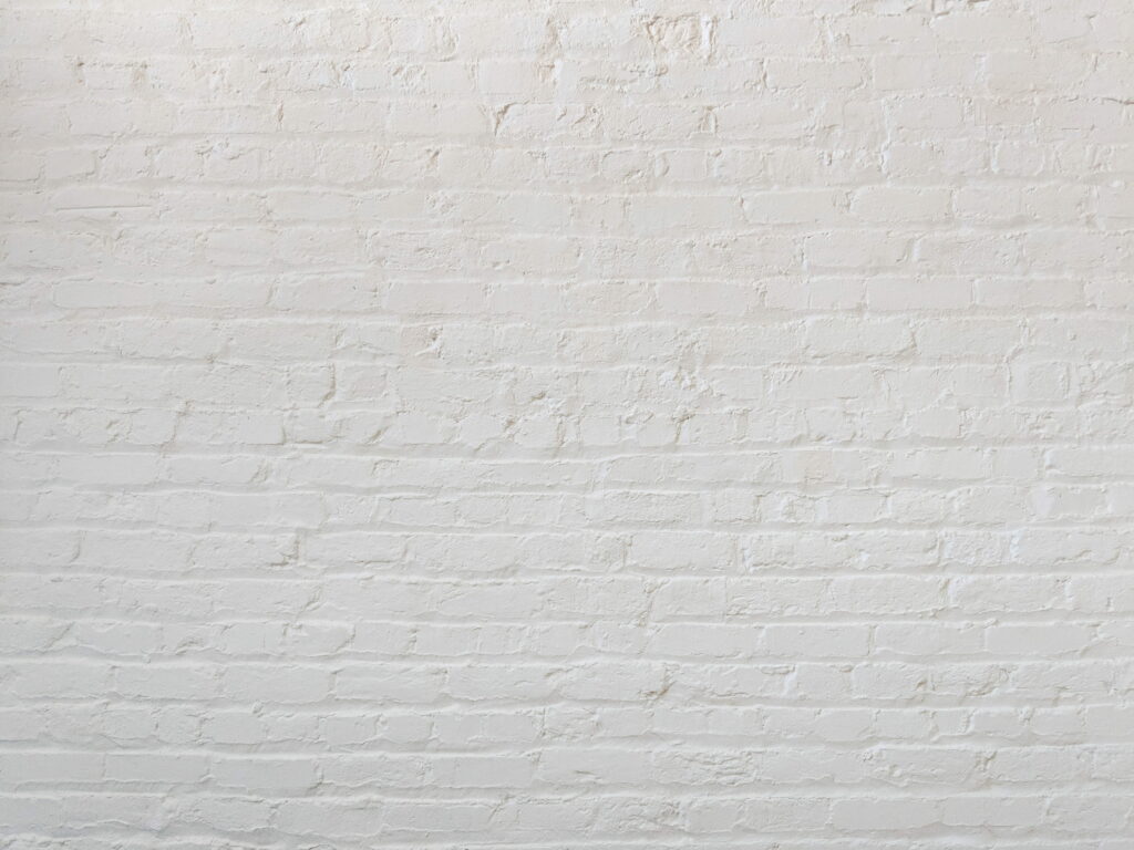 Blank Canvas: A Serene Minimalist Retreat Captured in a White Brick Wall Wallpaper