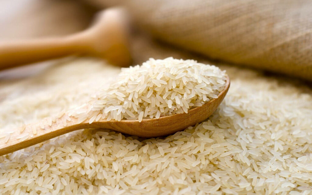 Warm Minimalist Wallpaper: Wooden Spoon with Refined Rice Over Grains