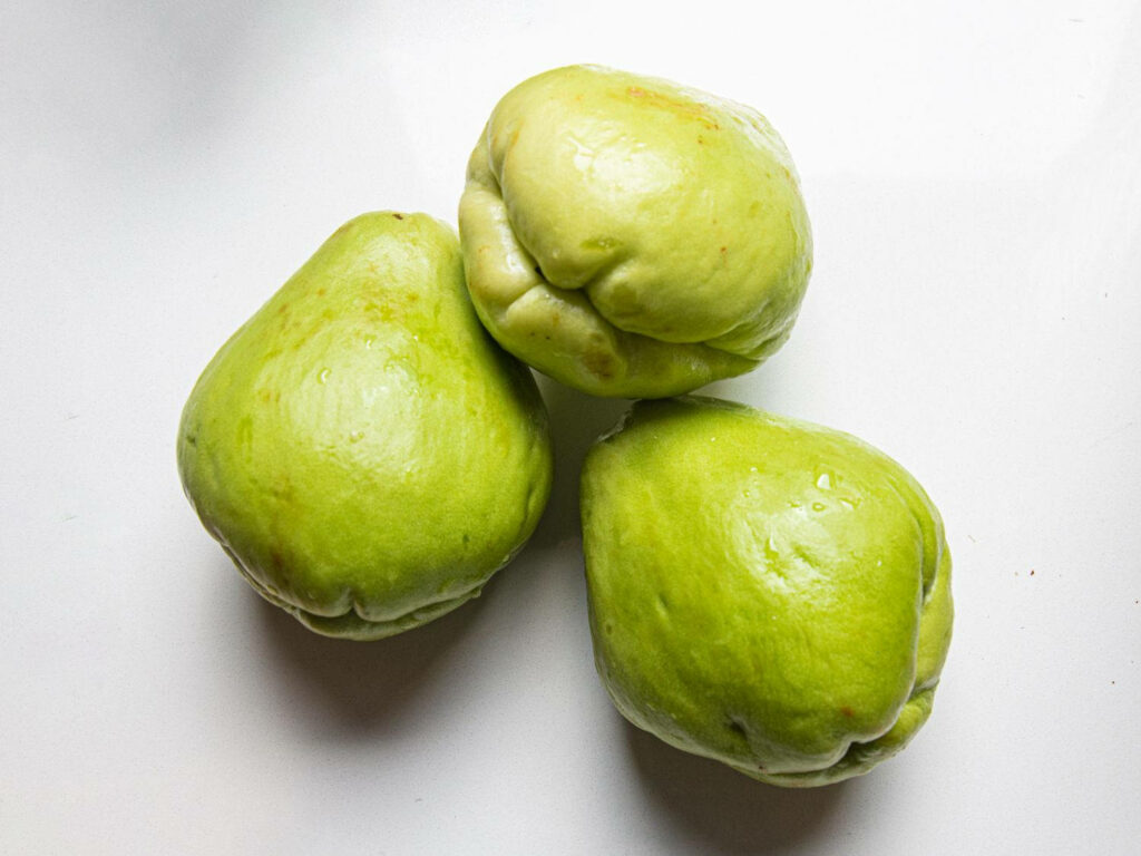 Minimalistic Green Chayote Fruits Wallpaper on White Background