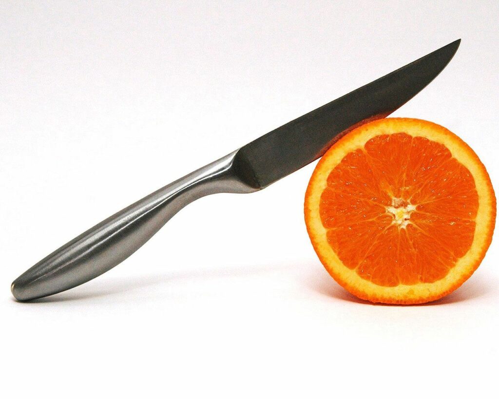 Minimalist Wallpaper: Sharp Knife & Fresh Orange Slice Composition