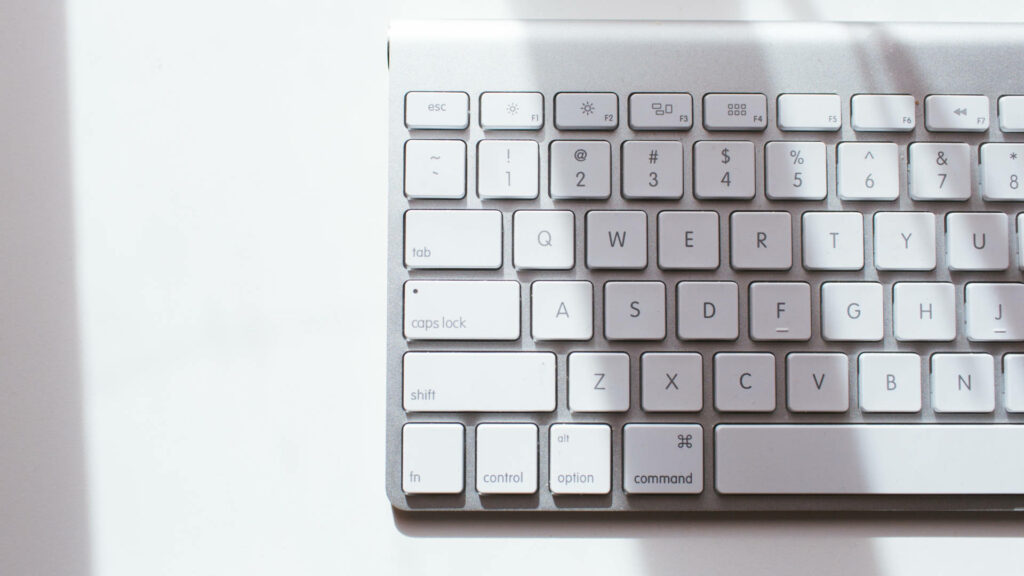 Minimalist Wallpaper: Sleek White Mac Keyboard with Soft Lighting