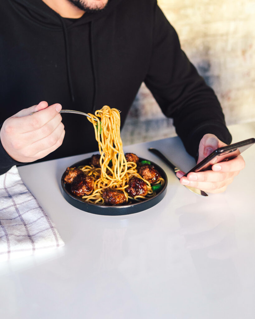 Minimalist iPhone Wallpaper: Man Enjoying Pasta & Meatballs