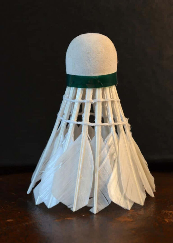 Graceful Solitude: A Minimalistic Badminton Still Life on Brown Surface Wallpaper