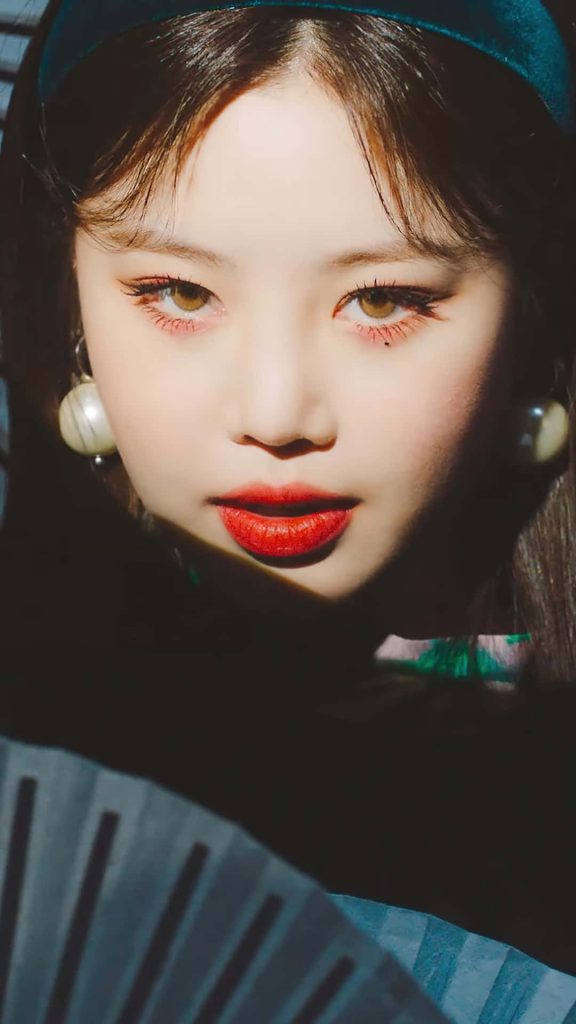 Elegant portrait of Minnie from GI-dle with dramatic lighting bold red lips and pearl earrings Wallpaper