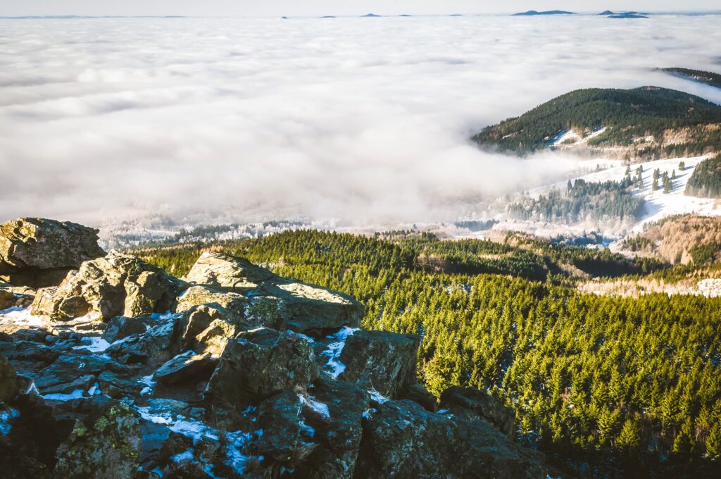 Misty Czech Republic mountains with rugged rocks and lush green forests in serene landscape Wallpaper