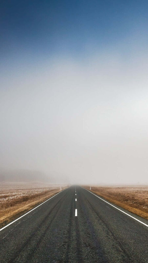 Solitude amidst the Mist: A Daytime Journey on an Empty Malibu Road Wallpaper