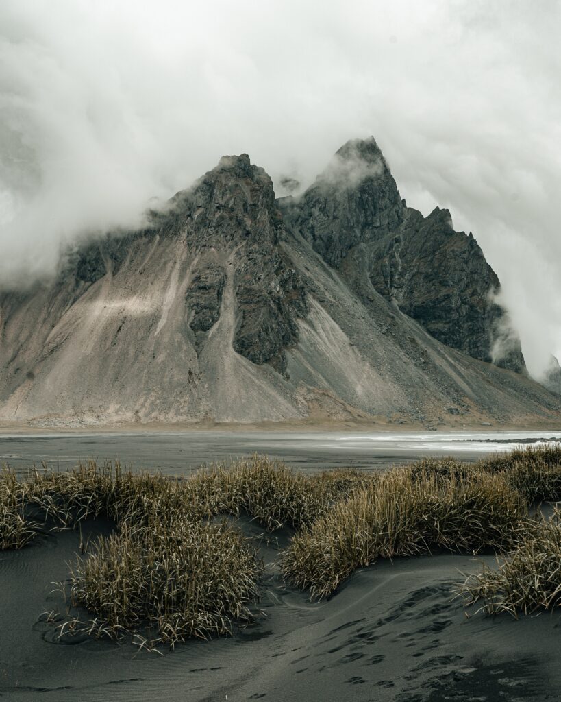 Dramatic misty mountain landscape with rugged rocks wild grass soft gray earthy tones wallpaper