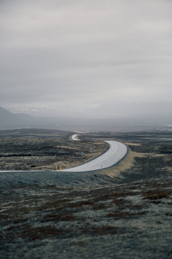 Winding road through foggy hilly mountains with misty atmosphere and rugged natural scenery Wallpaper
