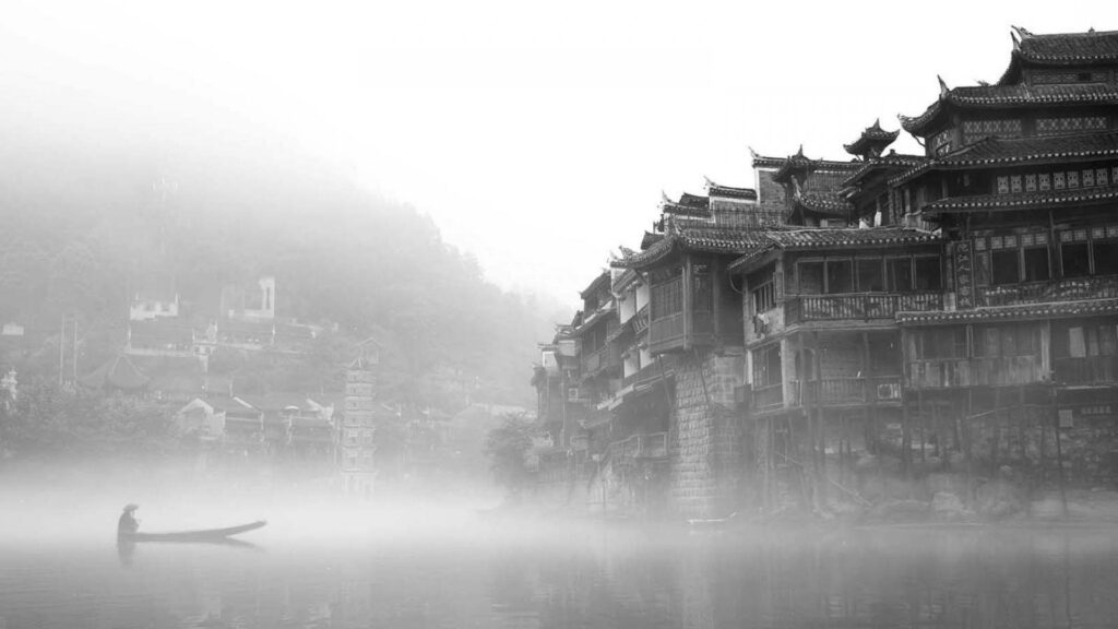 Monochrome wallpaper of traditional Chinatown wooden riverside houses with a solitary boat drifting