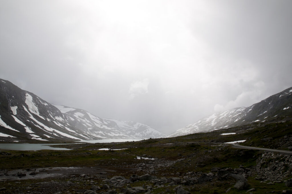 Misty valley with snow-capped mountains and calm lake reflecting foggy soft light wallpaper