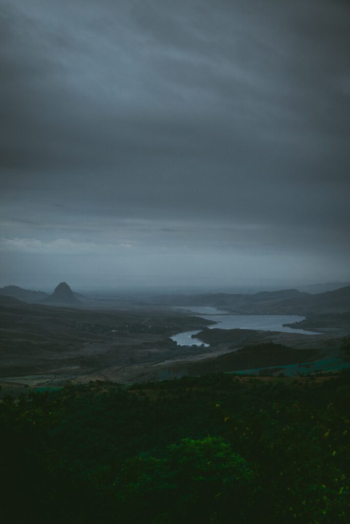 Aerial view of winding river in misty Armenian landscape with rolling hills and foggy sky Wallpaper