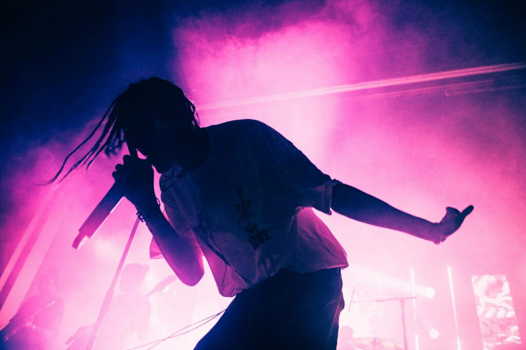 Mitchel Cave of Chase Atlantic silhouette on neon pink and purple lights vibrant wallpaper background
