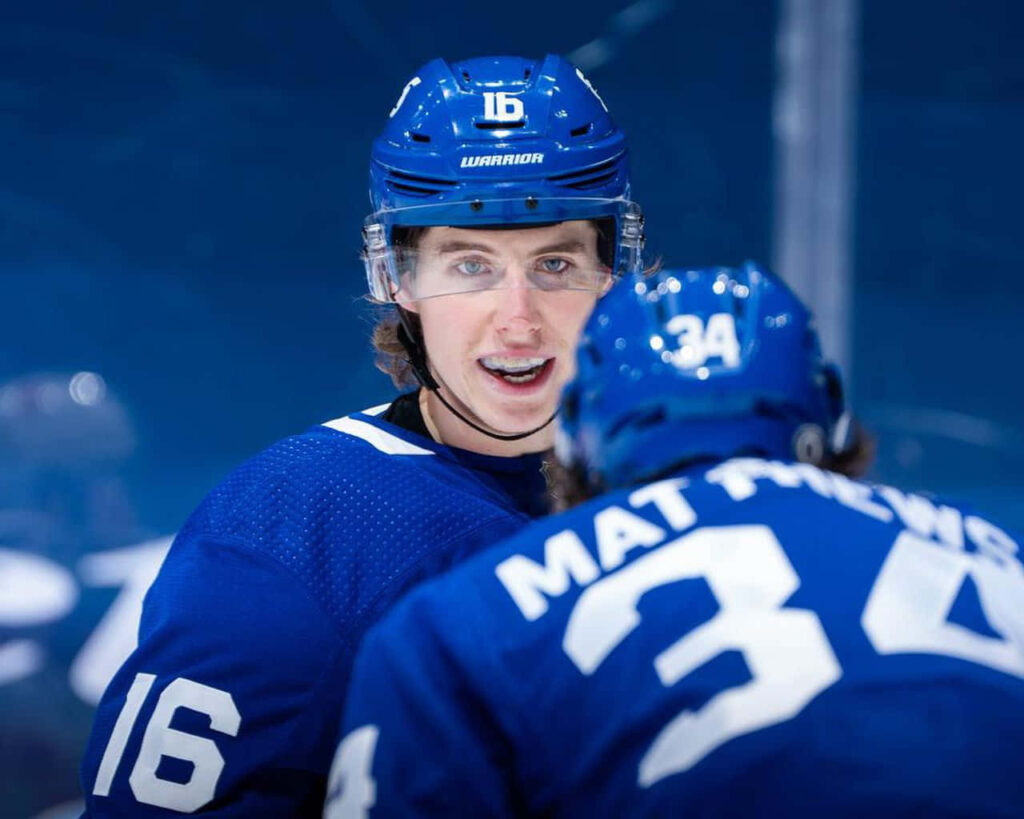 Mitchell Marner in blue Toronto Maple Leafs jersey focused during game with teammate foreground Wallpaper