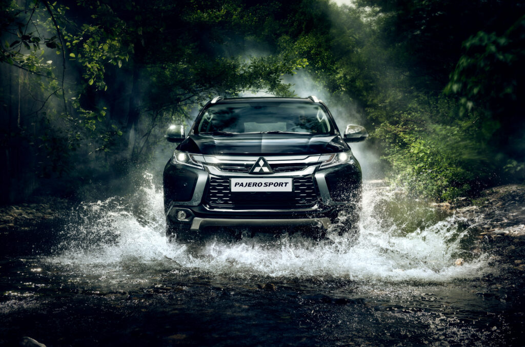Mitsubishi Pajero Sport: Rugged Adventure in Lush River Landscape Wallpaper