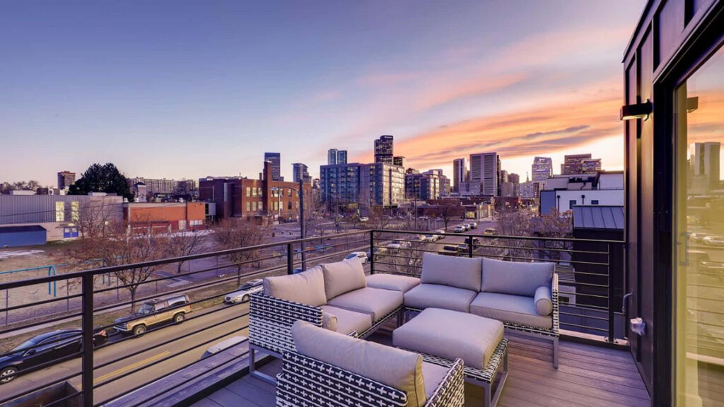 Stylish Urban Balcony: Cozy Couches & Stunning Sunset View Wallpaper