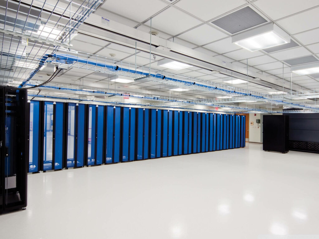 Modern wide data server room with sleek blue racks bright lighting and organized cables background Wallpaper