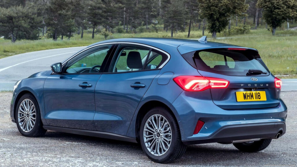 Modern blue Ford Focus parked roadside sleek rear design scenic green landscape wallpaper background