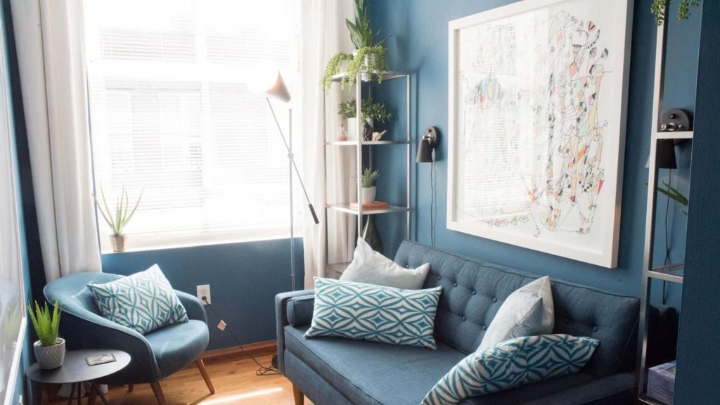 Cozy blue room wallpaper with stylish sofa abstract art and greenery for Zoom background