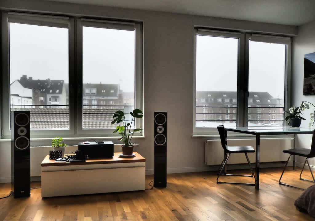Modern bright living room virtual Zoom background with polished wood floors and city view Wallpaper
