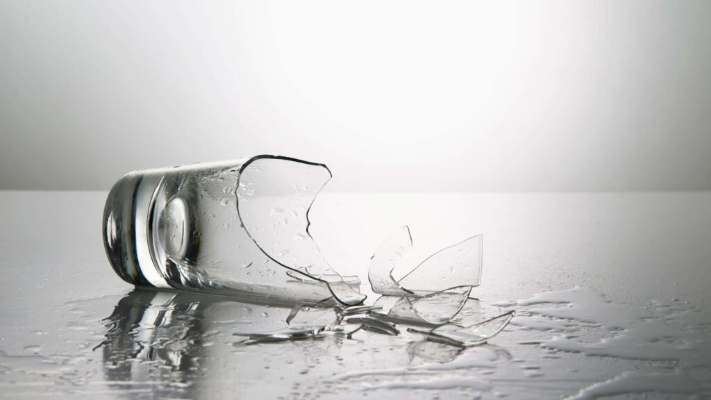Modern broken glass wallpaper with shattered fragments on glossy black surface and reflections